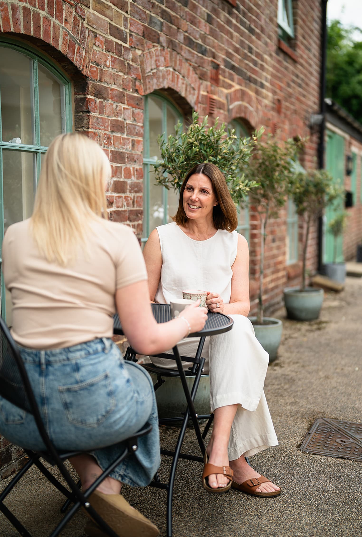 Rosie and Tiffany drinking tea together and having a chat about midwifery.