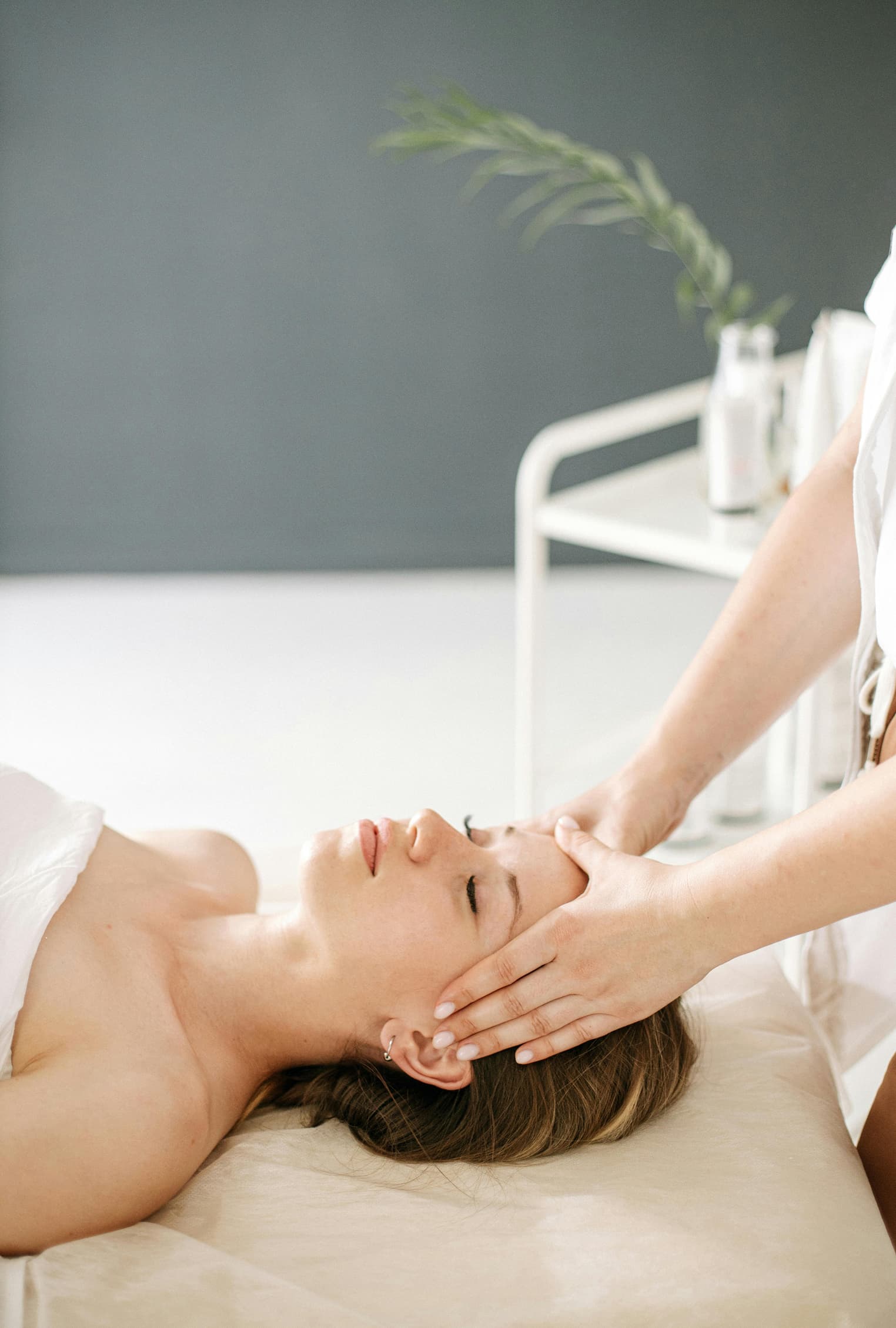 A relaxed lady receiving a well-deserved head massage.